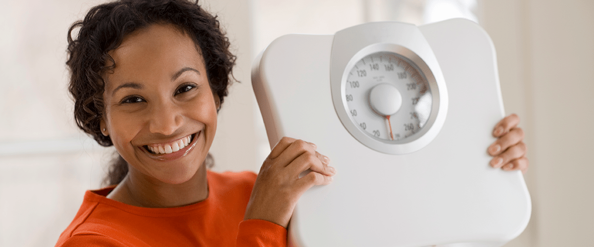 effects of weed on body weight - woman holding scale
